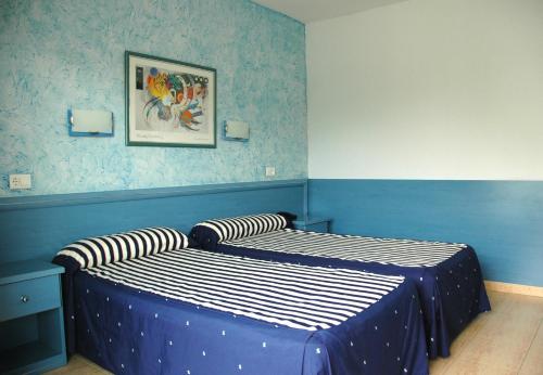 a bedroom with a blue and white striped bedspread at Santa Monica Playa in Salou