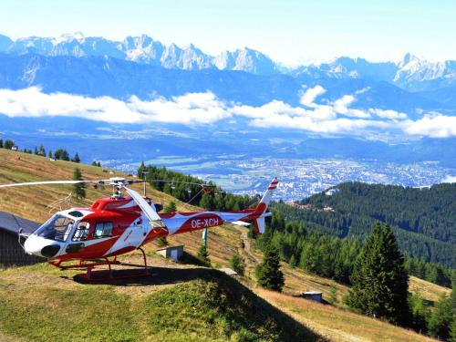 a red and white helicopter sitting on top of a hill at Alpinhotel Pacheiner in Treffen