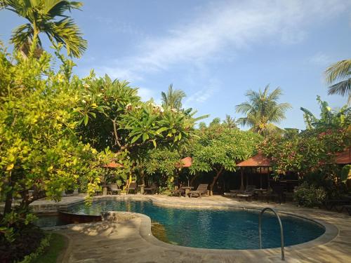 a pool in the middle of a resort with trees at Rini hotel in Lovina