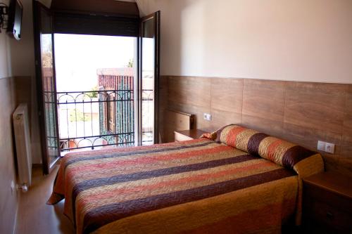 a bedroom with a bed and a large window at Domus Viatoris in Sahagún