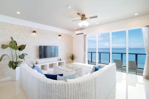 a living room with a view of the ocean at Costa Bella Condominium Resort in Motobu