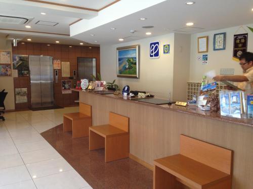 a man standing at a counter in a restaurant at Hotel Peace Island Miyakojima in Miyako Island