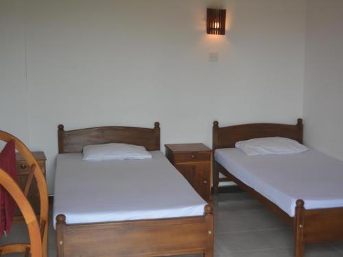 two twin beds in a room with at Shining Line in Koggala