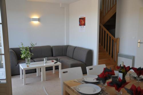 a living room with a couch and a table at Résidence L'Oustal Del Carlat in Carla-Bayle