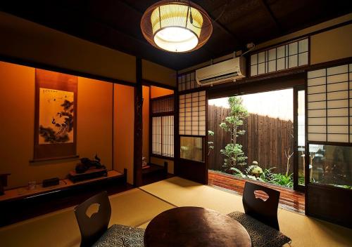 a room with a table and chairs and a large window at Inari Ohan in Kyoto