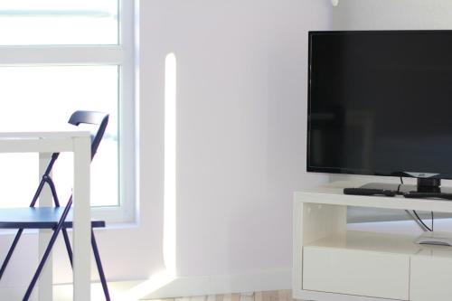 uma sala de estar com televisão num centro de entretenimento branco em Turquoise and Magenta Apartments em Sófia