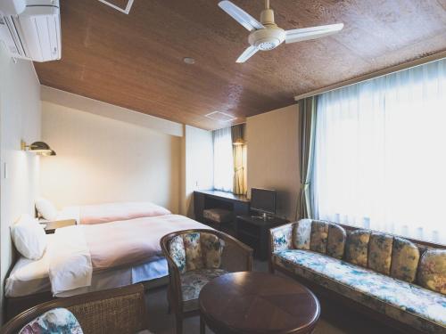 a hotel room with a bed and a table and chairs at Hotel Karuizawa Elegance in Karuizawa