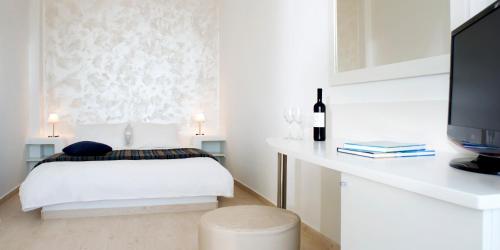 a bedroom with a bed and a desk at Tzekos Villas in Fira