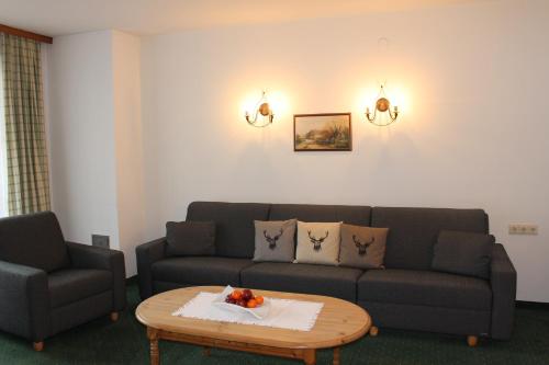 a living room with a couch and a coffee table at Apart Hotel Garni Strasser in Zell am Ziller