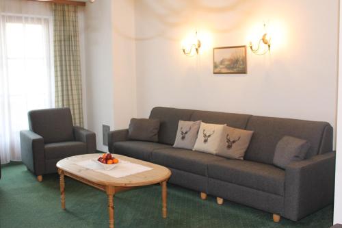 a living room with a couch and a coffee table at Apart Hotel Garni Strasser in Zell am Ziller