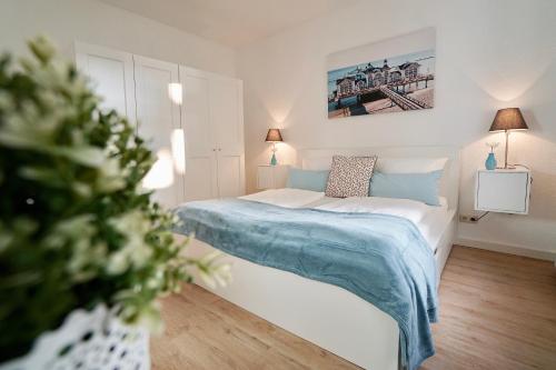 1 dormitorio con 1 cama y una pintura en la pared en MyHome Ruegen - Haus Johanneshorst, en Ostseebad Sellin