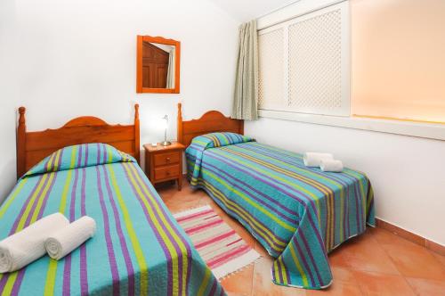 een slaapkamer met 2 bedden en een raam bij São Rafael Townhouse By OCvillas in Albufeira