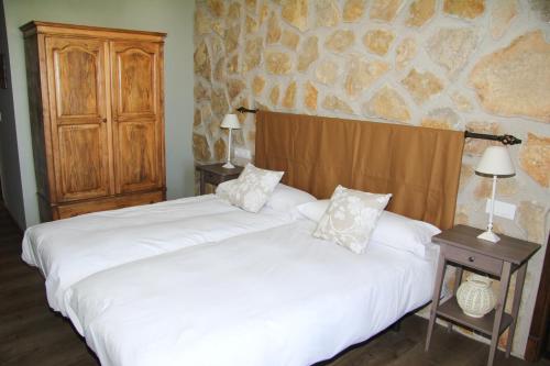 dwa łóżka ustawione obok siebie w sypialni w obiekcie Casa Rural El Olivar de Valdefuentes w mieście Valdefuentes
