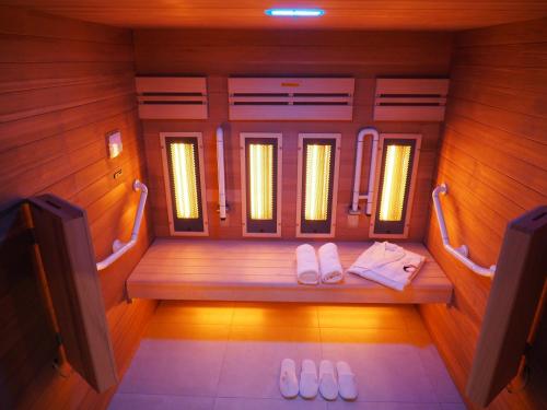 una sauna con un banco con dos zapatillas en Domaine du Revermont - Logis Hotel, en Passenans