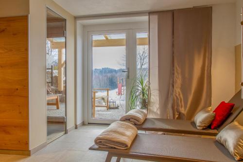 um quarto com uma janela e um banco com almofadas em Gästehaus "In da Wiesn" em Ulrichsberg