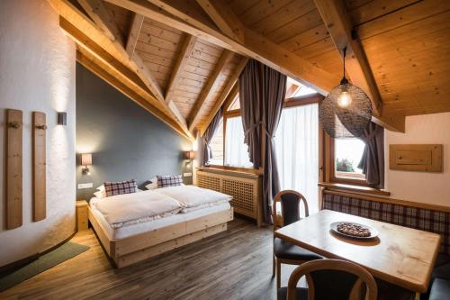 a bedroom with a bed and a table in a room at Residence Ciasa Giardun in La Villa
