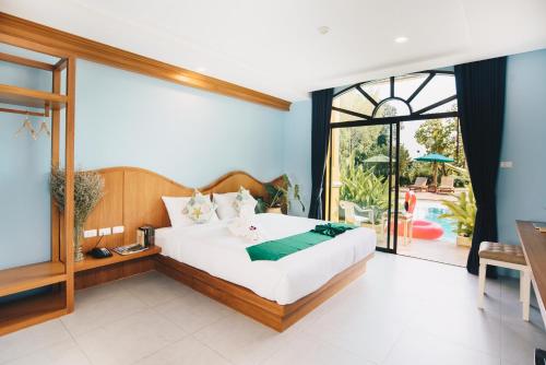 a bedroom with a large bed and a sliding glass door at The Pineapple Hotel in Krabi
