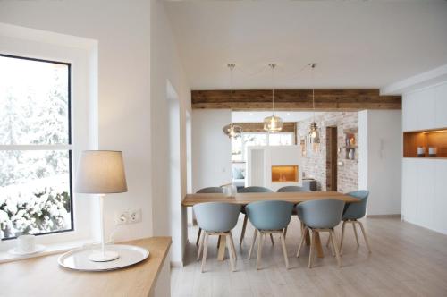 a dining room and kitchen with a table and chairs at Mountainlodge by Skischule Hermann Maier in Flachau