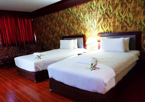 two beds in a hotel room with white sheets at JP Emerald Hotel in Yasothon