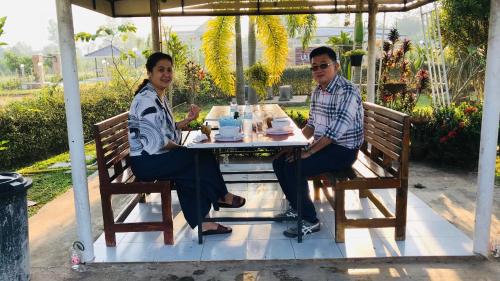 two men and a woman sitting at a table at Panutsaya Homestay in Wang Nam Khieo