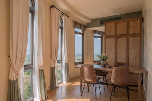 a dining room with a table and chairs and windows at Toscana Piazza in Mu Si