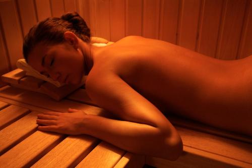 a woman laying on a wooden floor in a sauna at Hotel Abácie & Wellness in Valašské Meziříčí
