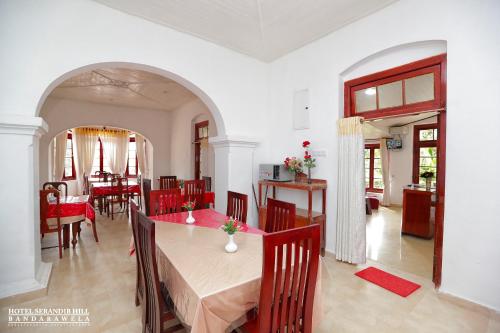 a dining room and living room with a table and chairs at Hotel Serendib Hill in Bandarawela