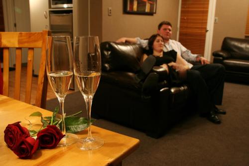 a man and a woman sitting in a couch with wine glasses at Millton Park Estate in Invercargill