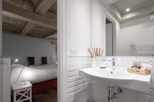 a white bathroom with a sink and a tub at Servi Suite in Florence