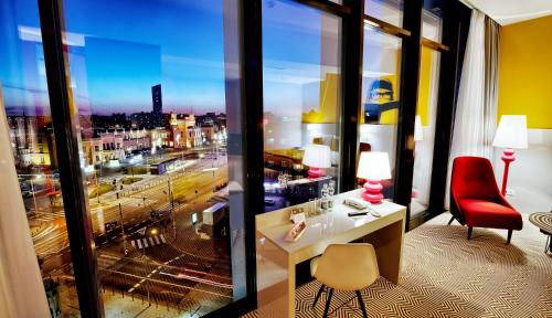 a hotel room with a desk and a view of a city at Ibis Styles Wroclaw Centrum in Wrocław