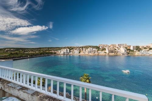 a view of a body of water from a balcony at Blue Harbour Seafront 3 bedroom apartment, with spectacular sea views from terrace - by Getawaysmalta in St. Paul's Bay