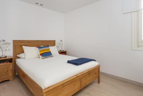 バルセロナにあるCasa Cosi - Mallorca 3のベッドルーム1室(白いシーツが備わる木製ベッド1台付)