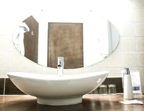 a white sink in a bathroom with a mirror at Hôtel De La Loge in Perpignan