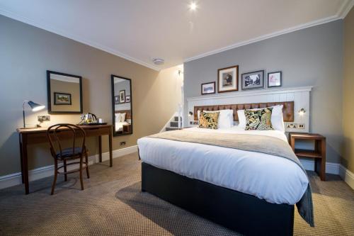 a bedroom with a bed and a desk and a chair at The Cheshire Cat by Innkeeper's Collection in Chester