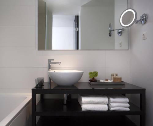 a bathroom with a sink and a mirror and towels at Sir Albert Hotel in Amsterdam