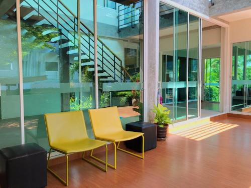 two yellow chairs and a table in a building at Siya Private Pool Villa Ao Nang in Ao Nang Beach
