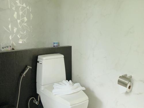 a white toilet in a bathroom with a toilet paper dispenser at Siya Private Pool Villa Ao Nang in Ao Nang Beach