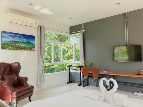 a living room with a chair and a desk and a window at Siya Private Pool Villa Ao Nang in Ao Nang Beach