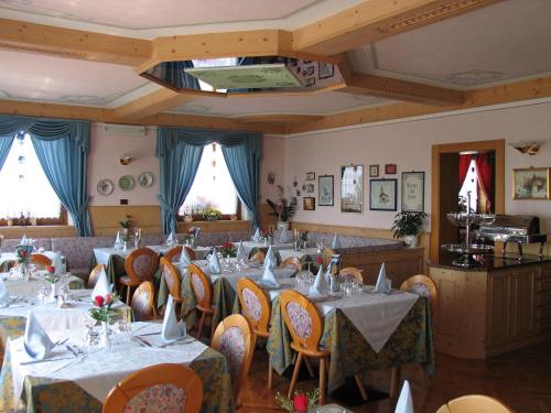 a restaurant with tables and chairs in a room at Hotel Negritella in Fai della Paganella