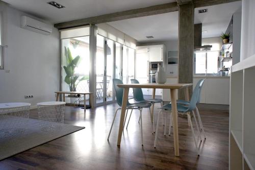 cocina y comedor con mesa y sillas en Apartamento Playa Cabanyal, en Valencia