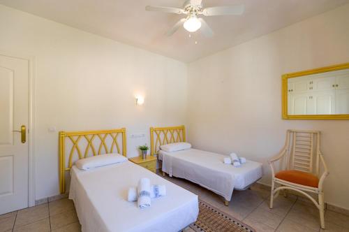 ベニッサにあるVillas Guzman - Olivosのベッド2台と天井ファンが備わる客室です。