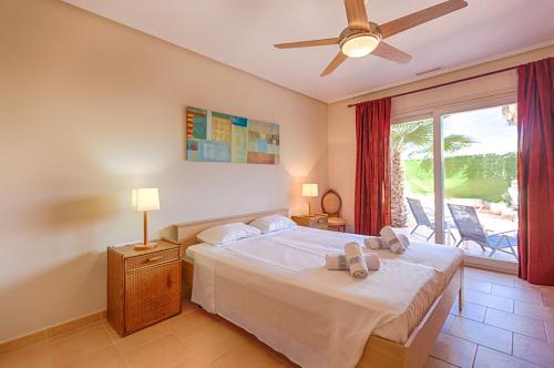 a bedroom with a bed with a ceiling fan and a window at Villas Guzman - Romero in Calpe
