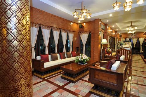 a living room with a couch and chairs in it at Sripat Guesthouse SHA Extra Plus in Chiang Mai