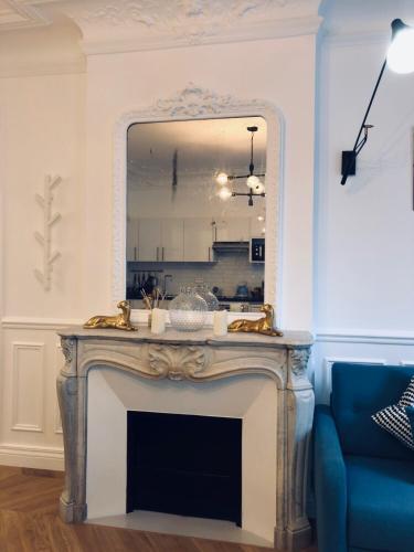 - un miroir au-dessus d'une cheminée dans le salon dans l'établissement RESIDENCE MONTORGUEIL, à Paris