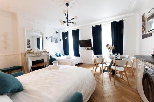 une chambre avec un grand lit et une table et des chaises dans l'établissement RESIDENCE MONTORGUEIL, à Paris
