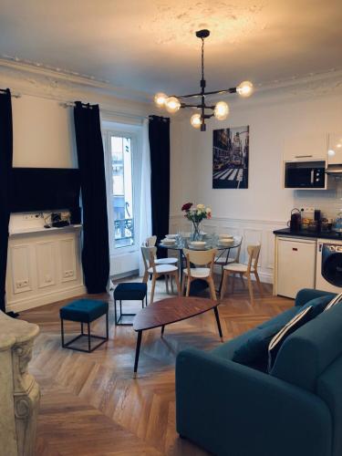 un salon avec un canapé bleu et une table dans l'établissement RESIDENCE MONTORGUEIL, à Paris