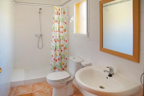 a bathroom with a toilet and a sink and a mirror at Villas Guzman - Apartamento Velazquez in Benitachell