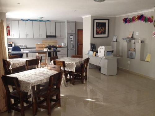 a kitchen and dining room with tables and chairs at Jessma Bed and Breakfast in Walvis Bay