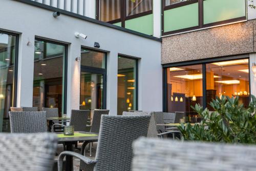 an empty patio with tables and chairs in front of a building at ParkHotel Fulda in Fulda