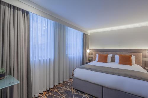 a bedroom with a bed and a large window at Richmond Hill Hotel in Richmond upon Thames